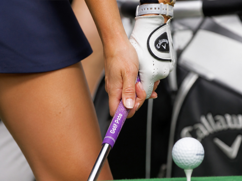 Woman beginner's hands showing correct golf grip placement on club