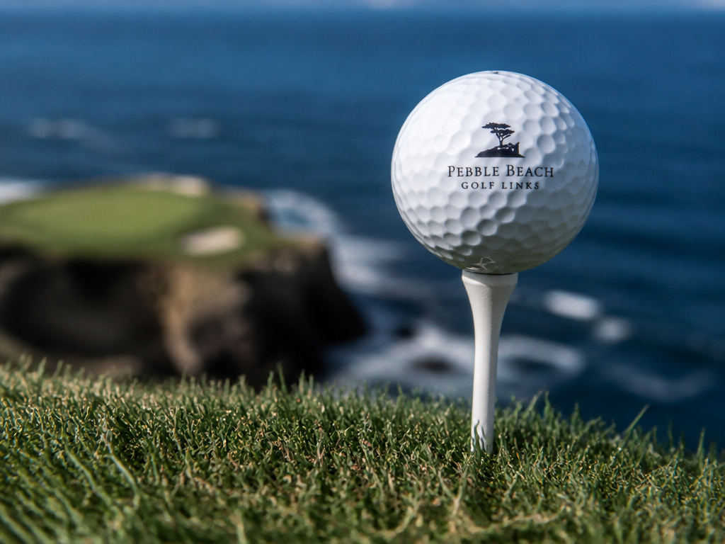 Golf ball on a cliff tee at Pebble Beach overlooking the Pacific Ocean.