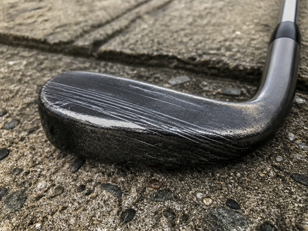Close-up of golf iron sole with scratch marks from concrete testing.