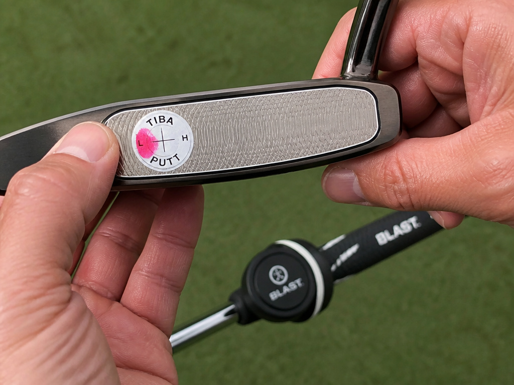 Impact tape on putter face shows off-center strike for speed control.